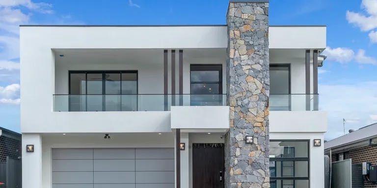 Double storey modern home with stacked stone facade and white exteriors
